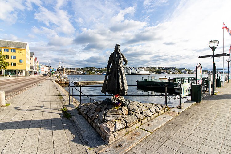 Workation in Norwegen, Kristiansund mit Figur einer Frau die einen Klippfisch in der Hand