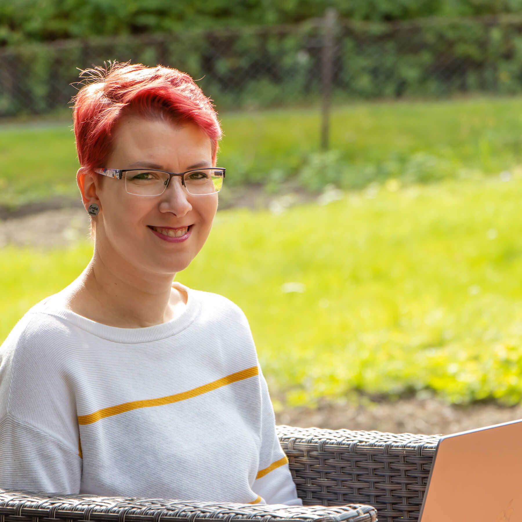 Workation in Norwegen, Miriam mit Laptop im Garten